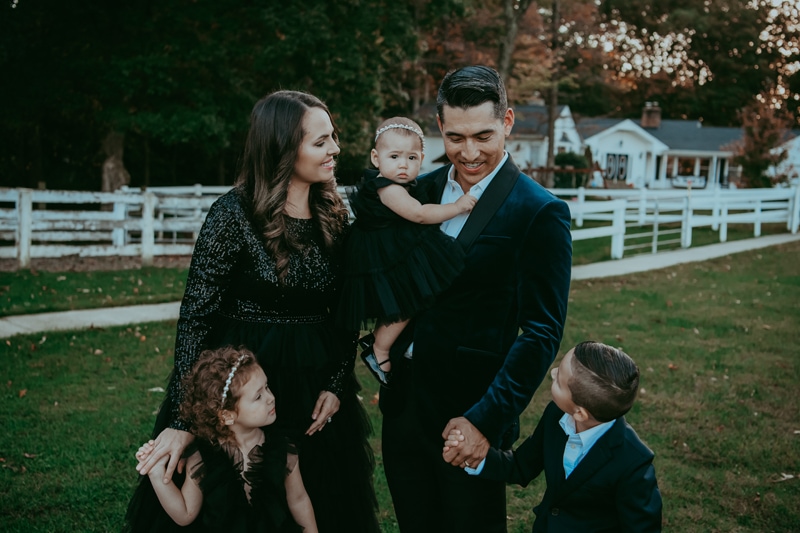 A family wearing black outfits during a fall outside family session captured by Bella Luna Photography in Fairfax, VA
