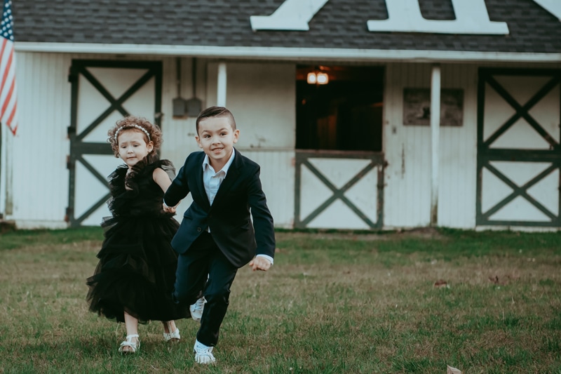 A brother is running while holding his sister's hand captured by Bella Luna Photography