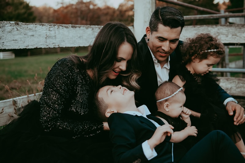 family of 5 is smiling and looking at each other during a family photo session in Loudoun County, VA