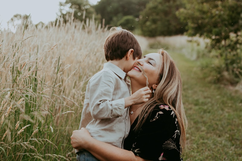 A mom is hugging her son during a golden hour family session in Leesburg, VA by Bella Luna Photography