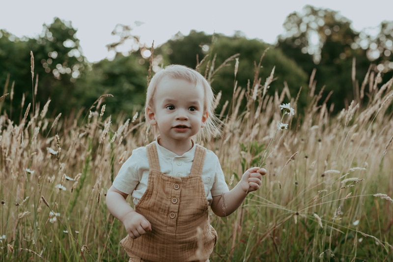 a boy holding a flower during a family photo session in Leesburg VA by Bella Luna Photography