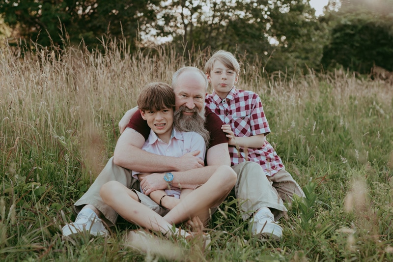 a dad is posing with his two sons during a family session in Leesburg by Bella Luna Photography